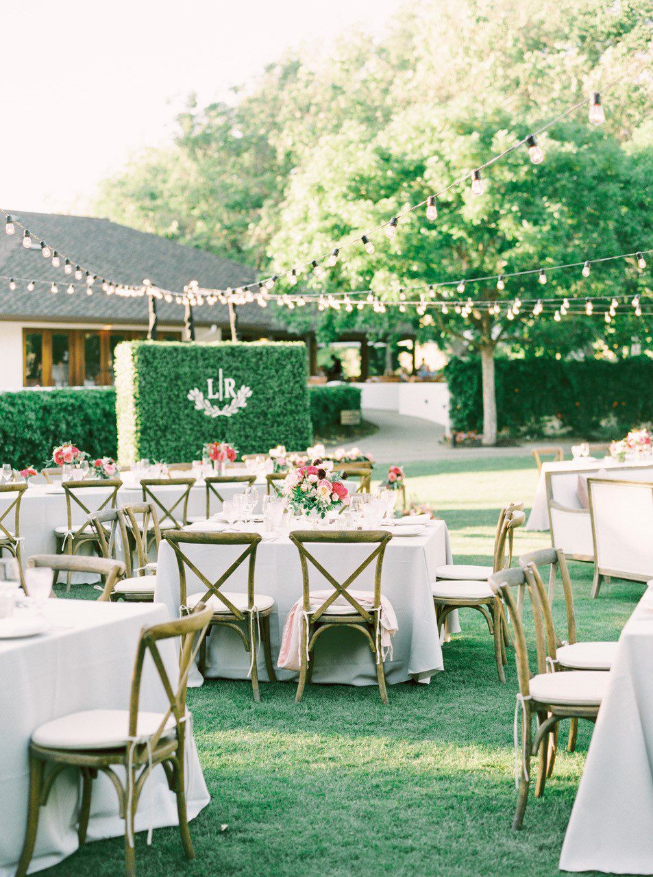 Wedding tables with tablecloths, flowers and chairs set up on the Vineyard Lawn.